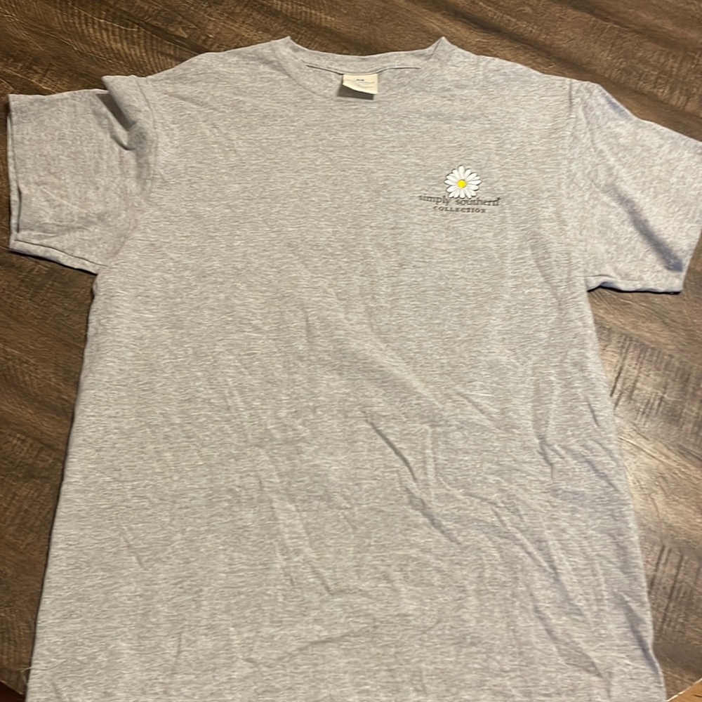 Color is gray design on the back is a volleyball with flowers and is 90% cotton